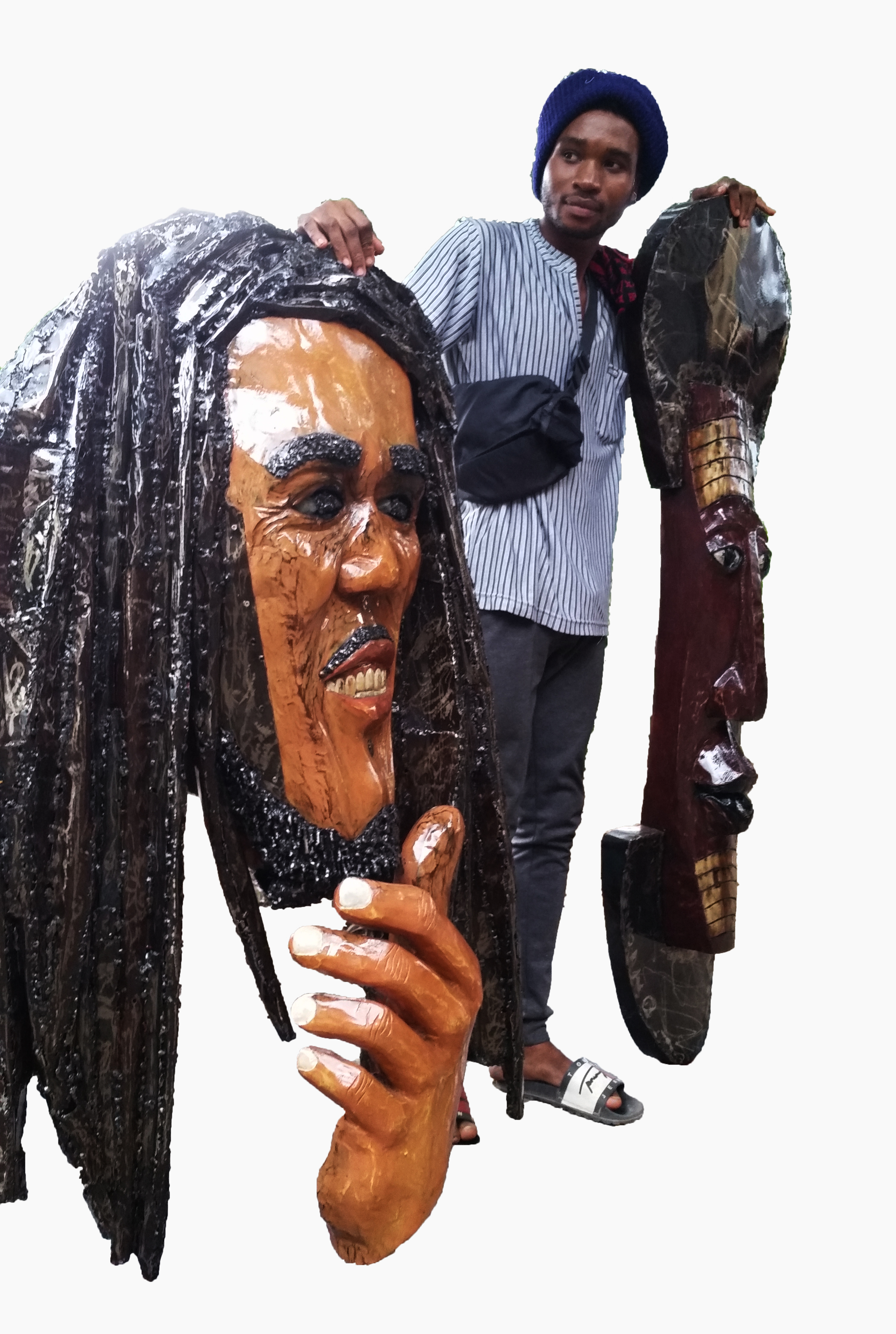 Jonathan Sonkola with two of his artworks: Bringing Back Memories (Bob Marley), 2019, wood and metal sheet, 135 x 89 x 17 cm, and My culture, (mask-like figure), 2019, wood and metal sheet, 66 x 18 x 7 cm.